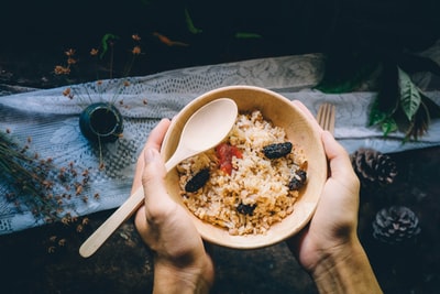 拿着装满食物的碗的人